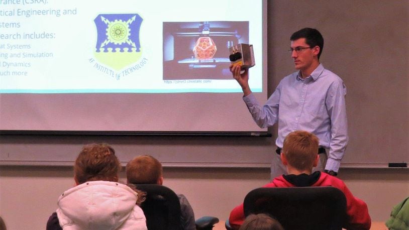 Air Force Institute of Technology astronautical engineering graduate student William Gallagher shows local students interested in space an example of CubeSat hardware from the Center for Space Research and Assurance. The mission shown is scheduled to launch in 2019. (U.S. Air Force photo/Jaclyn Knapp)