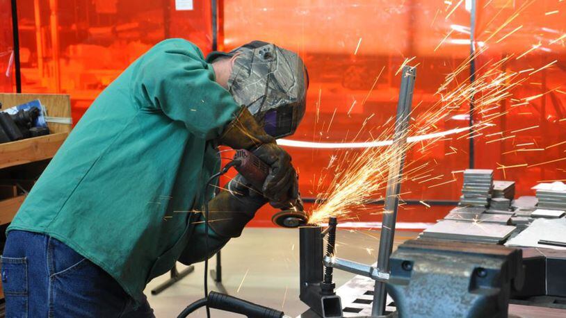Tom Nartker, welder and fabricator, grinds grinding a part for the AC-130J sensor special test equipment in the Rapid Development Integration Facility at Wright-Patterson Air Force Base. (U.S. Air Force photo/W. Eugene Barnett)