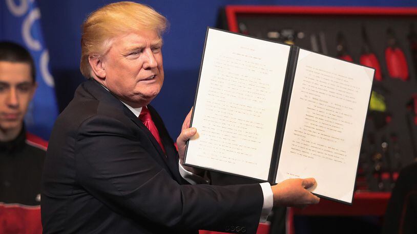 KENOSHA, WI - APRIL 18:  President Donald Trump signs an executive order to try to bring jobs back to American workers and revamp the H-1B visa guest worker program during a visit to the headquarters of tool manufacturer Snap-On on April 18, 2017 in Kenosha, Wisconsin.  (Photo by Scott Olson/Getty Images)