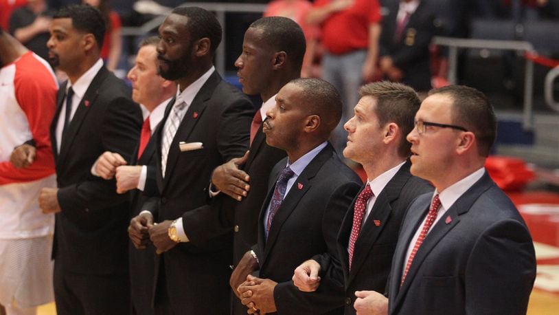 Dayton coaches, including head coach Anthony Grant (fourth from left) stand for the national anthem before a game against Ohio Dominican on Saturday, Nov. 4, 2017, at UD Arena. David Jablonski/Staff