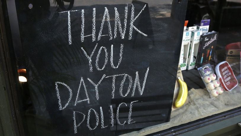Signs supporting the Dayton Police Department can be found throughout the Oregon District, including this chalkboard sign at Heart Mercantile. STAFF FILE