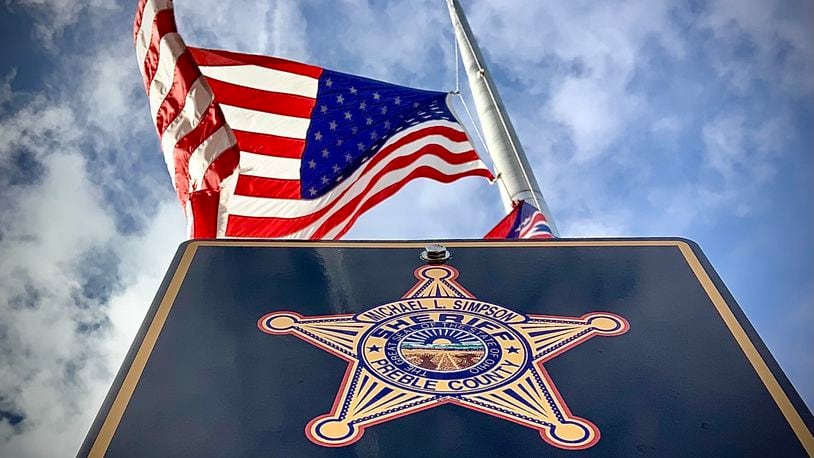 The American flag flies at half staff over the Preble County Sheriff's Office Monday, Dec. 18, 2018, after Deputy Joshua Hamilton was killed in an early morning head-on crash in his cruiser on state Route 503 between Gratis and West Alexandria. MARSHALL GORBY\STAFF