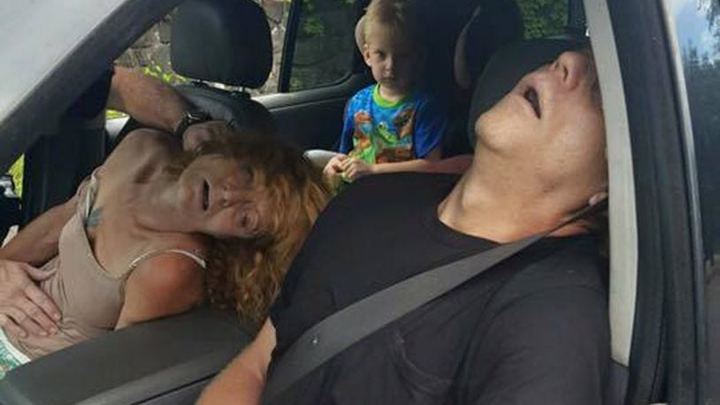 In this Wednesday, Sept. 7, 2016 photo released by the East Liverpool Police Department, a young child sits in a vehicle behind his mother and a man, both of whom are unconscious from a drug overdose, in East Liverpool, Ohio. Drug overdoses killed a record 3,050 people in Ohio last year. AP Photo.