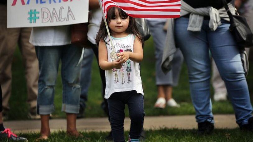 Serenity Moodt, 2, of Painesville waves a flag to protest President Donald Trump’s action to eliminate DACA, which allows young undocumented immigrants to stay in the United States. September 13, 2017 (Gus Chan / The Plain Dealer)
