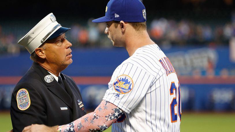 A member of the New York City Fire Department greets New York Mets' Pete Alonso during a Sept. 11, 2001, tribute before the team's baseball game against the Arizona Diamondbacks on Wednesday, Sept. 11, 2019, in New York.