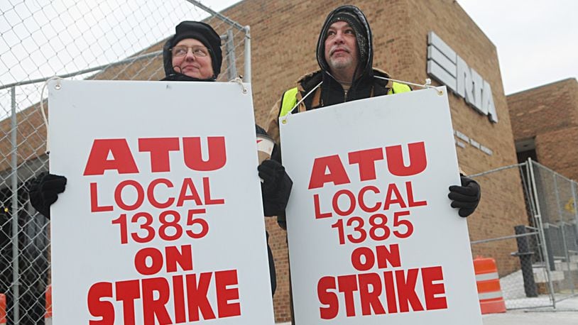 Elizabeth and Mike Hecker, both union employees of RTA, walk the picket line Monday at the Longworth Street Garage. STAFF PHOTO/MARSHALL GORBY