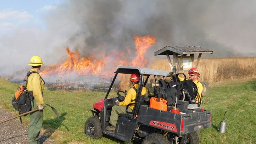 Darryn Warner, Natural Resources program manager, right, and personnel from the U.S. Fish and Wildlife Service Big Oaks Wildlife Refuge monitor a prescribed burn at the Huffman Prairie in 2016. (Courtesy photo)