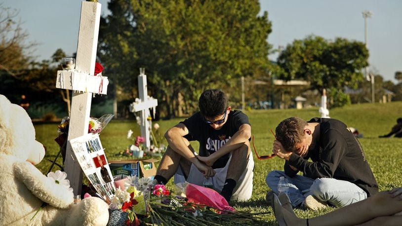 Students, friends and family gather at the memorial crosses at Pine Trails Park in Parkland, Fla., to remember those where were killed and injured in the shooting at Marjory Stoneman Douglas High School, on Friday, Feb. 16, 2018. (Carolyn Cole/Los Angeles Times/TNS)