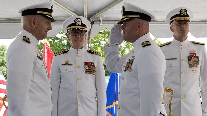 Capt. Rees Lee (front left) is relieved by Capt. Matthew Hebert (front right) who assumed the role of commanding officer, Naval Medical Research Unit Dayton Aug. 6. Capt. Adam Armstrong, commander, Naval Medical Research Center (middle), was the immediate superior in command and Rear Adm. Paul Pearigen, commander, Navy Medicine West (back right) was the presiding officer of the ceremony. (U.S. Air Force photo/Michelle Gigante)