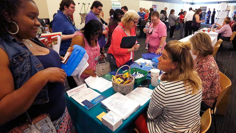 A group of people looking for jobs crowd around the Mercy Health-Springfield table at the Chamber of Greater Springfield and OhioMeansJobs Clark County job fair in 2016. Bill Lackey/Staff