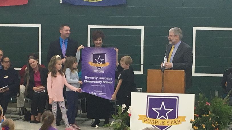 Students at Beverly Gardens Elementary in Riverside unfurl a new banner recognizing them as a Purple Star military-friendly school, while state schools superintendent Paolo DeMaria (right) speaks to students on Nov. 2, 2017. JEREMY P. KELLEY / STAFF