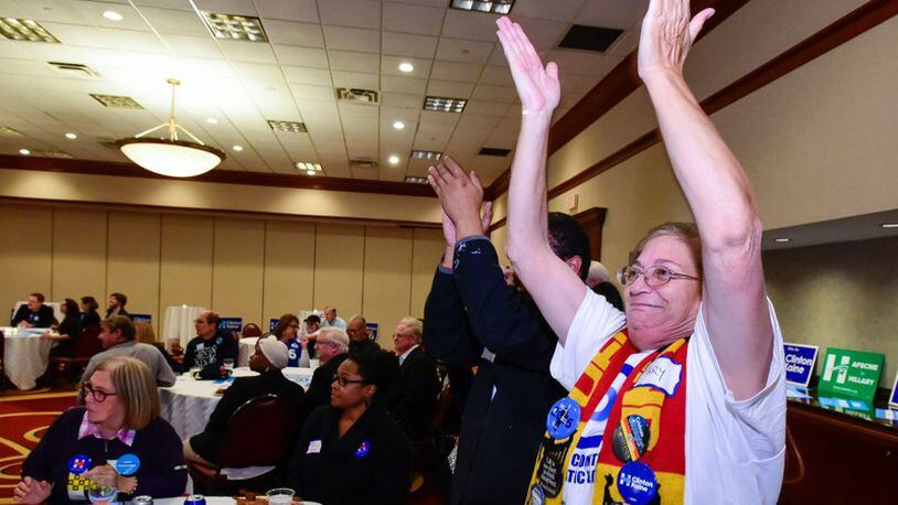 Mary Williams, right, and Will Goins cheer as a state is called in Hillary Clinton’s favor during the Butler County Democratic party election results watch event Tuesday, Nov. 8 at the Marriott ballroom in West Chester Twp. NICK GRAHAM/STAFF