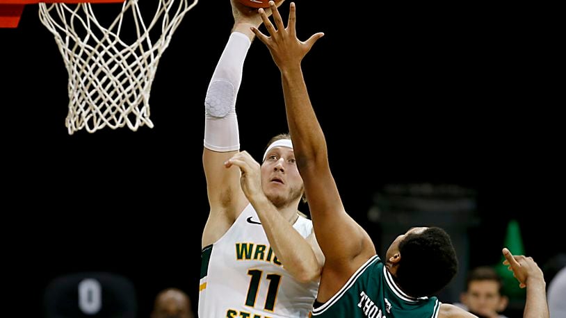 Wright State center Loudon Love gets the basket against Green Bay forward Terrance Thompson during a men's basketball game at the Nutter Center in Fairborn Saturday, Dec. 26, 2020. E.L. Hubbard/CONTRIBUTED