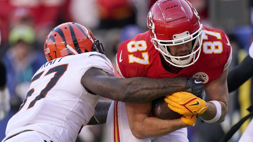 Kansas City Chiefs tight end Travis Kelce (87) tries to break a tackle by Cincinnati Bengals linebacker Germaine Pratt (57) after catching a pass during the first half of the AFC championship NFL football game, Sunday, Jan. 30, 2022, in Kansas City, Mo. (AP Photo/Charlie Riedel)