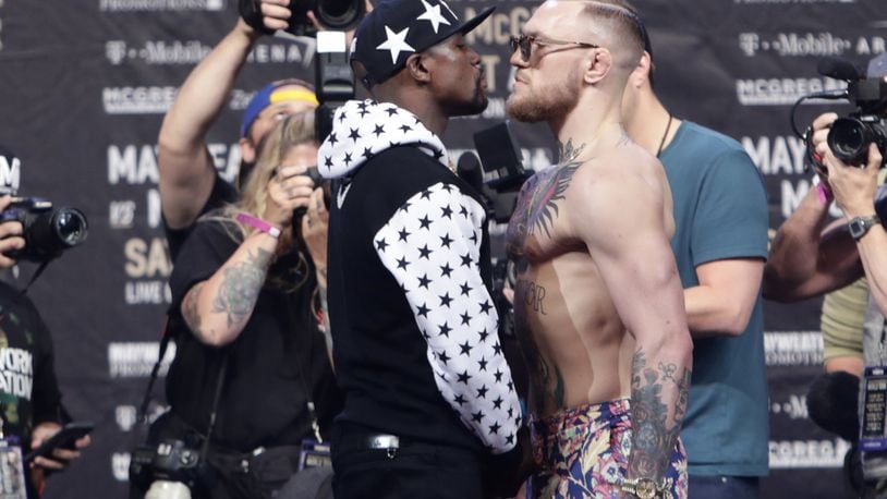 This July 13, 2017 photo shows Floyd Mayweather Jr., left, and Conor McGregor, of Ireland, facing each other for photos during a news conference at Barclays Center in New York. So far fans aren't exactly storming the box office to buy tickets for Mayweather Jr.'s fight next month with McGregor. A check online Saturday, July 29, 2017 revealed hundreds _ even thousands _ of seats still available from Ticketmaster at the T-Mobile arena for the Aug. 26 fight. There are so many open seats that fans with enough room left on their credit cards can buy six tickets together in 162 different spots throughout the arena. (AP Photo/Frank Franklin II)