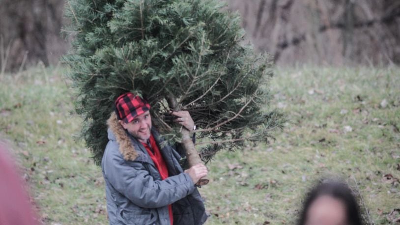 Sean Crowe, from Kettering, drops off his tree at Eastwood Metro Park. JIM NOELKER/STAFF