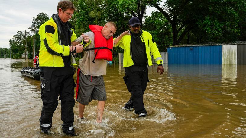 FILE - Tim McCanon, center, is rescued by the Community Fire Department during severe flooding on Friday, May 3, 2024, in New Caney, Texas. In a world growing increasingly accustomed to wild weather swings, the last few days and weeks have seemingly taken those environmental extremes to a new level. (Raquel Natalicchio/Houston Chronicle via AP, File)