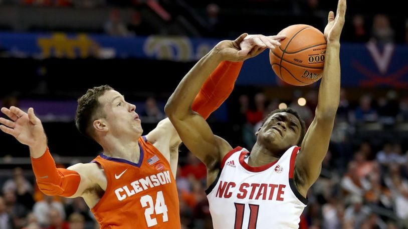 CHARLOTTE, NORTH CAROLINA - MARCH 13: Markell Johnson #11 of the NC State Wolfpack drives to the basket against Devon Daniels #24 of the Clemson Tigers during their game in the second round of the 2019 Men’s ACC Basketball Tournament at Spectrum Center on March 13, 2019 in Charlotte, North Carolina. (Photo by Streeter Lecka/Getty Images)