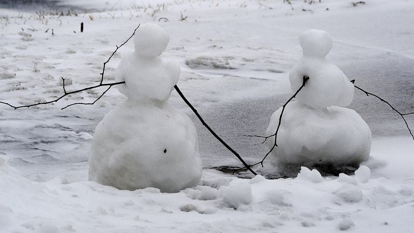 Someone built two little snowmen on the sidewalk near the University of Dayton campus Monday, Feb. 1, 2021.