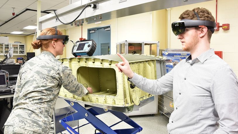 Air Force Research Laboratory Materials and Manufacturing Directorate researchers Capt. Sarah Wallentine and Alex Brown demonstrate the use of augmented reality for nondestructive inspections. AFRL researchers are developing a capability that uses the technology to display all necessary information for performing an aircraft inspection within the user’s field of view, eliminating the need to view information from multiple sources simultaneously. (U.S. Air Force photo/David Dixon)