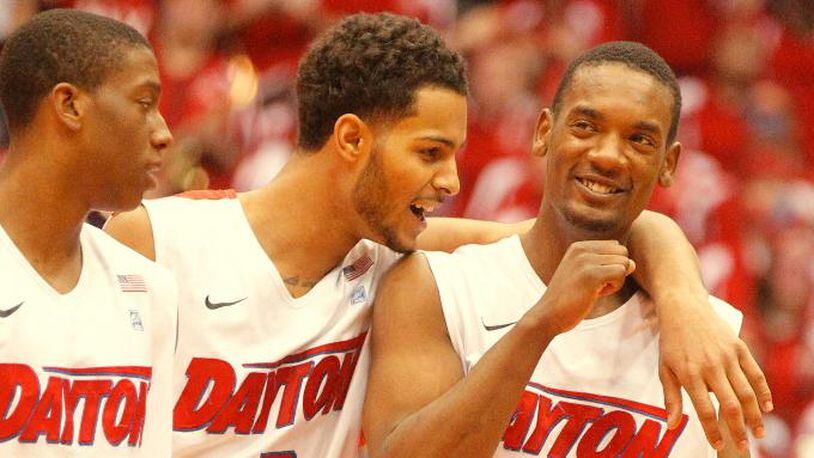Dayton’s Jordan Sibert, left, Devin Oliver, center, and Dyshawn Pierre celebrate in the final seconds of a victory against Massachusetts on Saturday, March 1, 2014, at UD Arena. David Jablonski/Staff