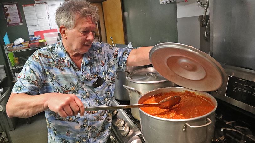 Fred Stegner, president of the Springfield Soup Kitchen, stirs the pasta sauce being served for dinner at the kitchen Monday night. BILL LACKEY/STAFF