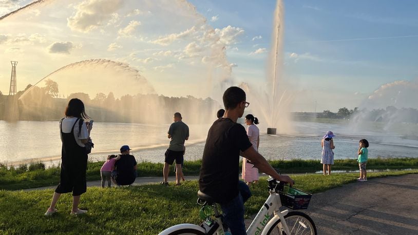 A man rides on one of Link's electric-assisted bicycles by the fountains at RiverScape MetroPark. CORNELIUS FROLIK / STAFF