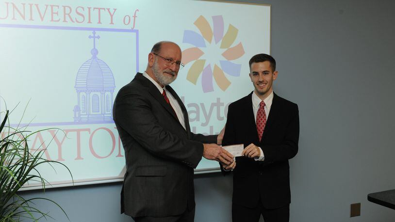 Brandon Mayforth, a UD senior, presents a $500 check to Adam Mezoff, vice president and chief medical officer at Dayton Children’s Hospital. Mezoff discovered Mayforth suffered from a rare disease during his freshman year at UD.