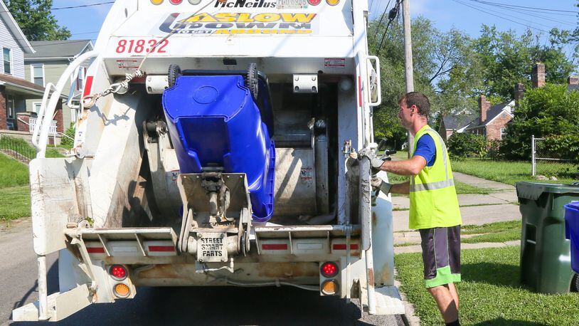 Rumpke trash collector Mike McDonald in July was busy working his route along Millikin St. GREG LYNCH / STAFF