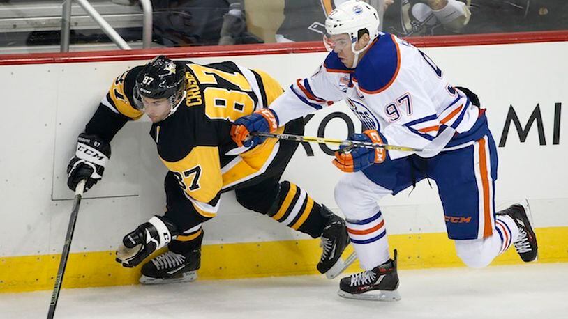 In this Nov. 8, 2016, file photo, Edmonton Oilers' Connor McDavid (97) and Pittsburgh Penguins' Sidney Crosby (87) battle for the puck during the first period of an NHL hockey game in Pittsburgh. Coming off back-to-back Conn Smythe Trophies as playoff MVP with the Stanley Cup champion Penguins, Crosby is widely considered by his peers as the best player in hockey. Crosby has just one true rival in that department: 20-year-old reigning MVP Connor McDavid, whose speed makes him a threat to be the NHL's best for the next decade or more.  (AP Photo/Gene J. Puskar, File)