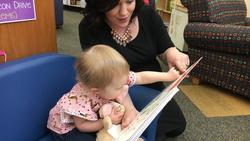 Kari Egbers, of Monroe, says reading to her daughter, Eliot Rose, 2, is part of their daily routine. She participates in the Dolly Parton Imagination Library. RICK McCRABB/STAFF