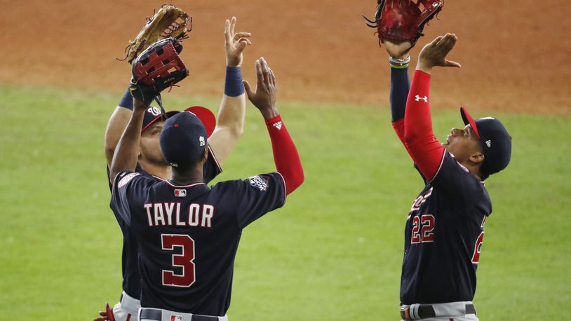 HOUSTON, TEXAS - OCTOBER 23:  Juan Soto #22, Michael A. Taylor #3 and Gerardo Parra #88 of the Washington Nationals celebrate their 12-3 win over the Houston Astros in Game Two of the 2019 World Series at Minute Maid Park on October 23, 2019 in Houston, Texas. (Photo by Tim Warner/Getty Images)