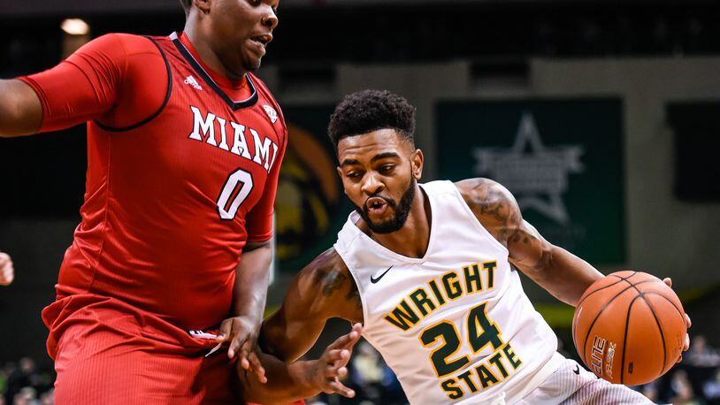 Wright State University’s Mark Alstork dribbles under the hoop defended by Miami University’s Darius Harper during their 89-87 win Miami Tuesday, Nov. 15 at Wright State University’s Nutter Center in Fairborn. NICK GRAHAM/STAFF