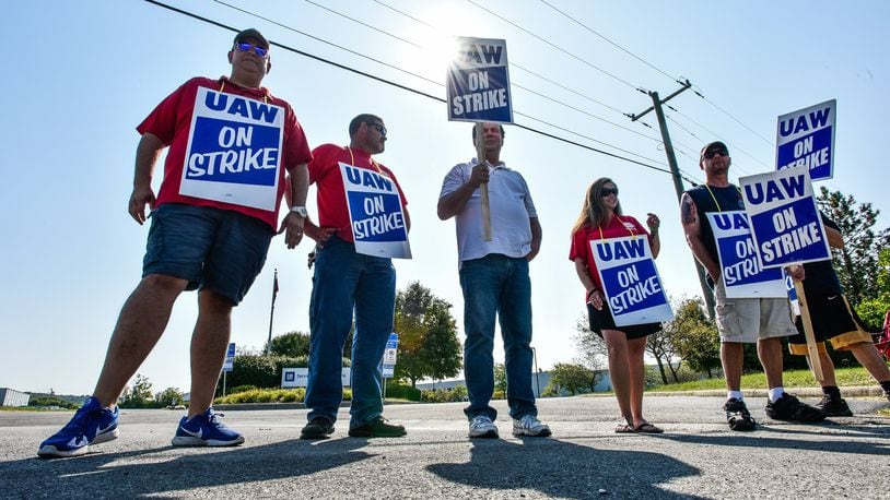 Employees stand near the entrance to the General Motors Service Parts Operations facility on Jacquemin Drive in West Chester Township as they join many United Auto Workers union employees around the country on strike against the automaker Monday, Sept. 16, 2019. NICK GRAHAM/STAFF