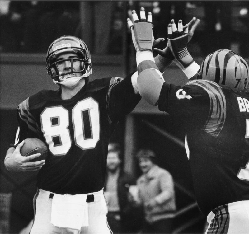Cincinnati Bengals wide receiver Cris Collinsworth receives congratulations from teammate Ross Browner after catching a first quarter touchdown pass during their game with Atlanta Falcons at Riverfront Stadium in Cincinnati, Nov. 26, 1984. The bengals beat the Falcons 35-14. (AP Photo/Rob Burns)