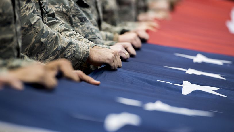 FILE: Airmen from Wright-Patterson Air Force Base, Ohio, hold a large, garrison-size American flag at half court during pregame ceremonies prior to the NCAA First Four Tournament at the University of Dayton Arena in Dayton, Ohio, March 14, 2018. During the game’s halftime events, Lt. Gen. Robert McMurry Jr., Air Force Life Cycle Management Center commander, also administered the oath of enlistment to delayed enlistment to 32 personnel. (U.S. Air Force photo by Wesley Farnsworth)