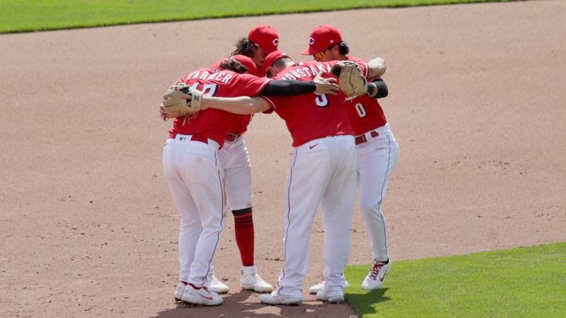 Reds infielders celebrate after a victory against the Pirates on Wednesday, April 7, 2021, at Great American Ball Park in Cincinnati. David Jablonski/Staff
