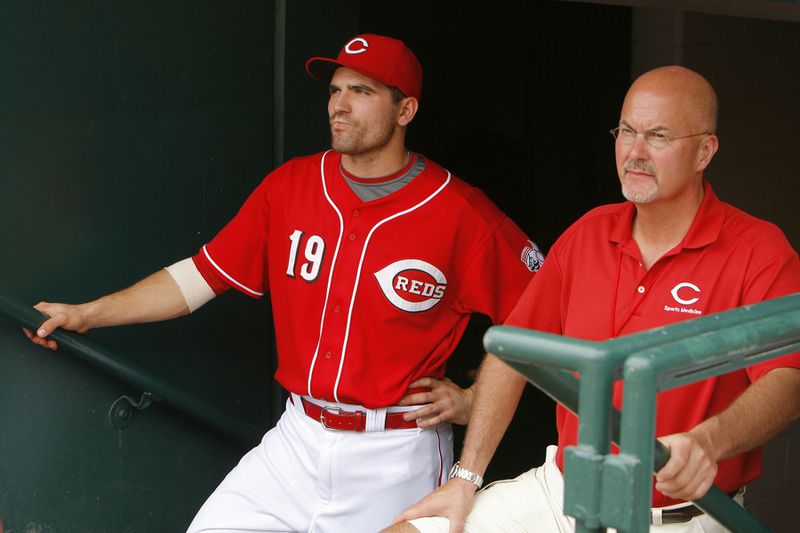 Reds Medical Director Tim Kremchek, right, stands with Joey Votto in the Cincinnati Reds dugout. Photo courtesy of Beacon Orthopaedics & Sports Medicine
