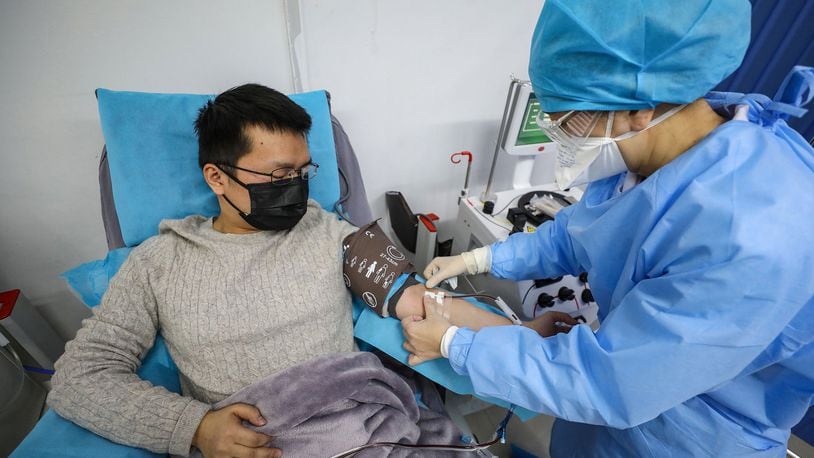 This photo taken on February 18, 2020 shows a doctor, left, who has recovered from the COVID-19 coronavirus infection donating plasma in Wuhan, China. (AFP/Getty Images/TNS)