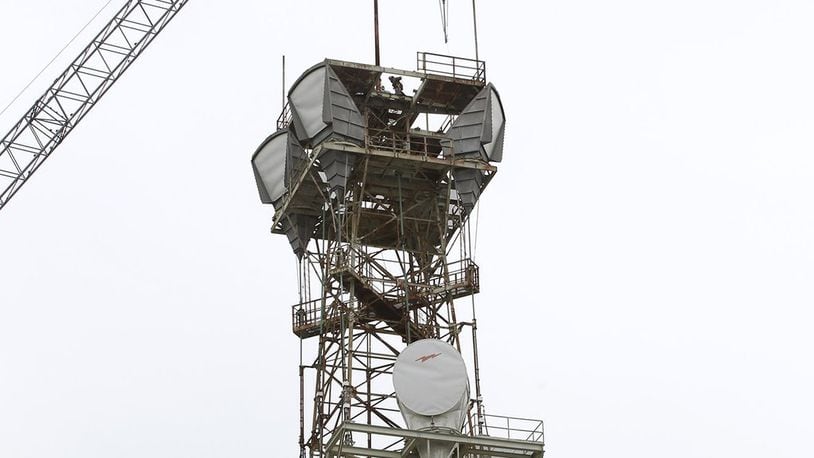 Workers tear down at microwave tower on top of the AT&T building in downtown Dayton. Ty Greenlees