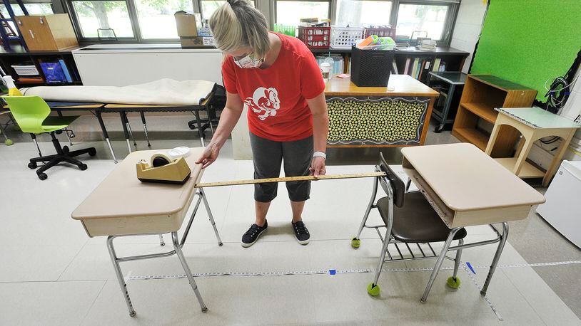 Orchard Park Elementary, Second grade teacher, Kristie Schuller, uses a yardstick and a tape measure to help with social distancing of desk for her class to start the new year. MARSHALL GORBY\STAFF