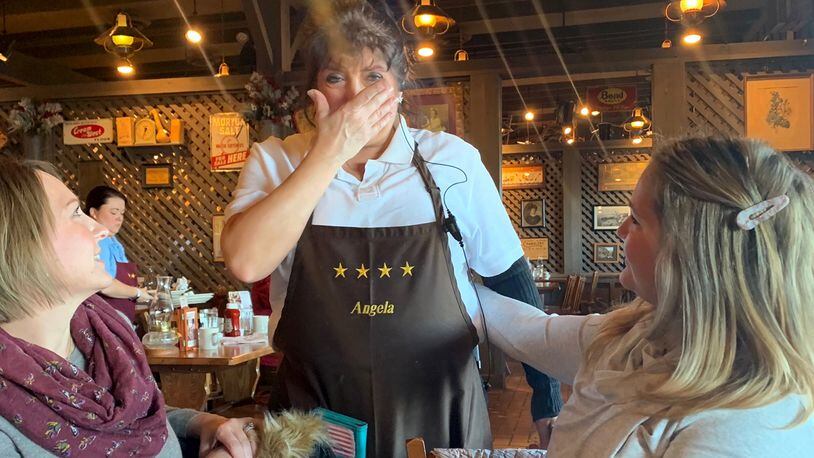 Angela Fuller of West Carrolton, a waitress at Cracker Barrel, was visited by a group of "Breakfast Santas" organized by Monica Deal of Centerville. The group of 11 women left Fuller a $1,000 tip. CONTRIBUTED PHOTO