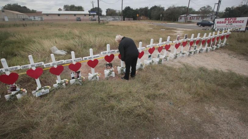 SUTHERLAND SPRINGS, TX - NOVEMBER 09: Helen Biesenbach leaves a message at a memorial where 26 crosses were placed to honor the 26 victims killed at the First Baptist Church of Sutherland Springs on November 9, 2017 in Sutherland Springs, Texas. On November 5, a gunman, Devin Patrick Kelley, shot and killed the 26 people and wounded 20 others when he opened fire during Sunday service at the church. Biesenbach, a member of the church, missed the November 5 service because she was babysitting her two-year-old grandson who was home with a fever. Biesenbach knew all the victims whose names are written on the crosses.   (Photo by Scott Olson/Getty Images)