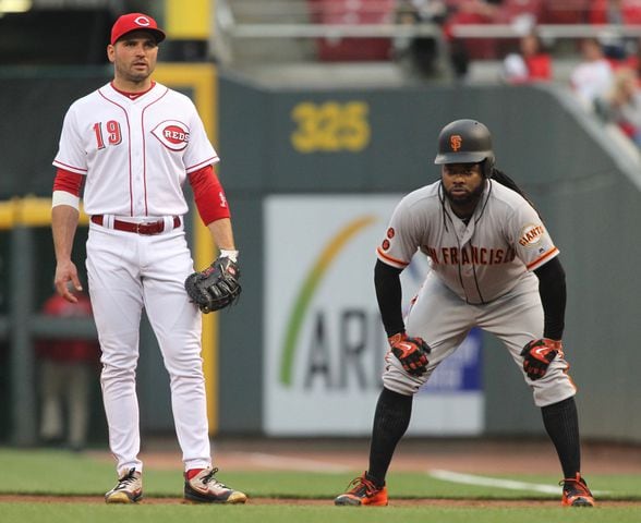 The Giants' Johnny Cueto, right, leads off in front of Reds first baseman Joey Votto on Monday, May 2, 2016, at Great American Ball Park in Cincinnati. David Jablonski/Staff