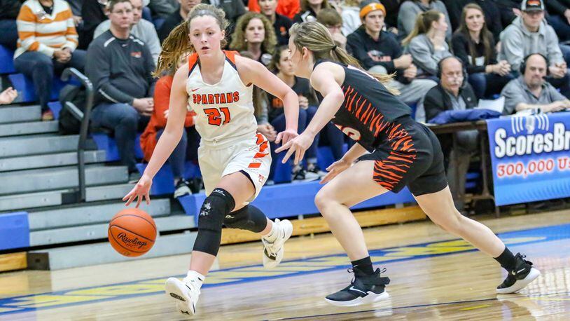 Waynesville High School’s Rachel Murray drives to the hoop against Versailles’ Hannah Barga during their Division III regional semifinal game on Wednesday night at Springfield High School. The Spartans won 55-45. CONTRIBUTED PHOTO BY MICHAEL COOPER