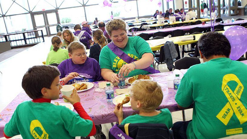 Evan Pina-White (facing on left), 13, from Eureka and his mother Mary White (facing on right) sit with the rest of their family during the Rockwood School District's American Cancer Society Relay for Life survivor's dinner on Friday, June 1, 2012, in Fenton. Pictured from left to right in the foreground are White's other sons Bennett Pina-White, 8, Gabe Pina-White, 6, and her husband Luis Pina. (Johnny Andrews/St. Louis Post-Dispatch/TNS)