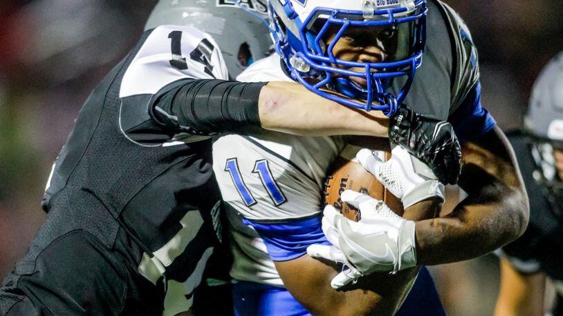 Hamilton’s Vince Sanford gets wrapped up by Lakota East’s Allen Jantausch during East’ 31-28 Week 6 win. East is at Fairfield on Friday and Hamilton hosts Middletown. NICK GRAHAM/STAFF