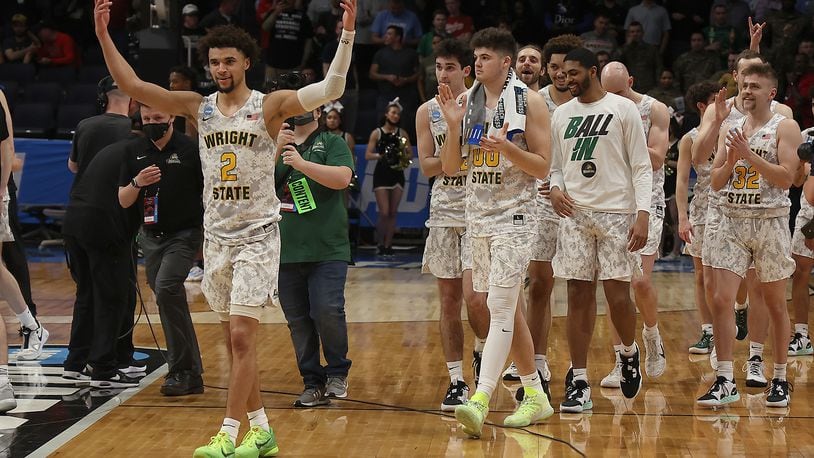 The Wright State Raiders, led by Tanner Holden, march off the court victorious Wednesday, March 16, 2022 after defeating Bryant in the First Four game. BILL LACKEY/STAFF