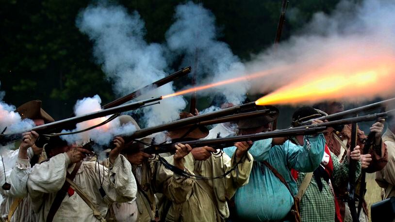Fire explodes from a row of militia muskets as the militiamen in the 225th anniversary re-enactment of the Battle of Peckuwe take aim at the Native American warriors Sunday, July 17, 2005, at George Rogers Clark Park in Springfield, Ohio. The re-enactment commemorates the largest Revolutionary War battle fought west of the Allegheny Mountains which took place on the site of the current county park. Bill Lackey/Staff