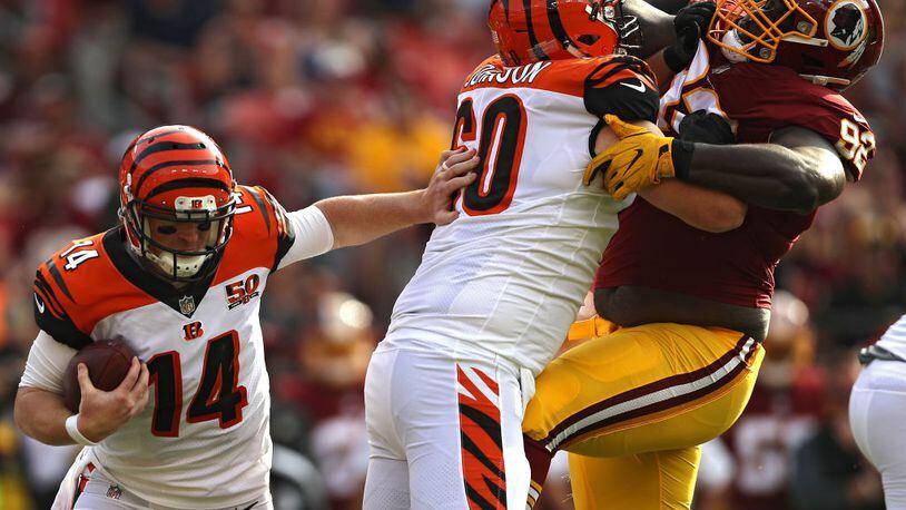 LANDOVER, MD - AUGUST 27: Quarterback Andy Dalton #14 of the Cincinnati Bengals rushes as teammate T.J. Johnson #60 blocks defensive tackle Stacy McGee #92 of the Washington Redskins in the second quarter during a preseason game at FedExField on August 27, 2017 in Landover, Maryland. (Photo by Patrick Smith/Getty Images)